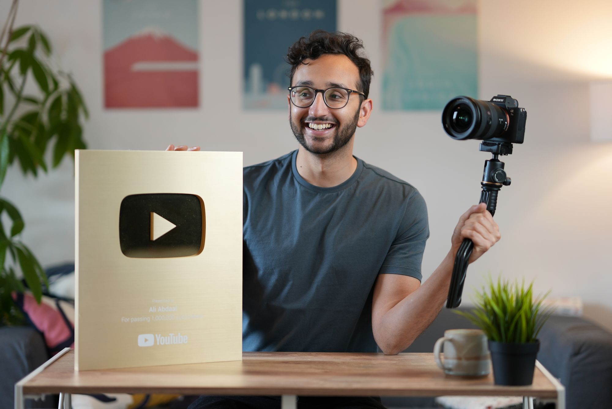 Ali holding his 2M plaque and a DSLR camera