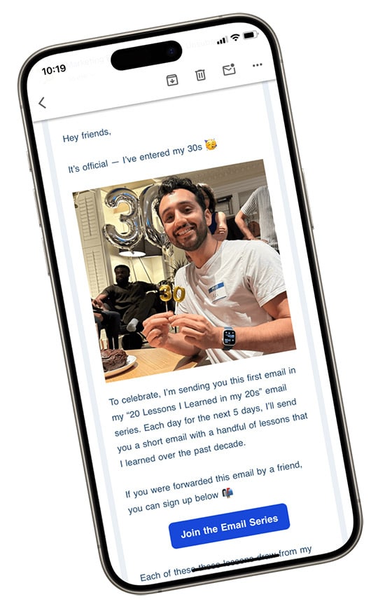 mobile phone mockup with a picture of Ali Abdaal celebrating his 30th birthday. Ali Abdaal is holding up birthday candles and has silver baloons in the background